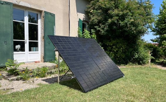 Panneau solaire posé au sol devant une maison